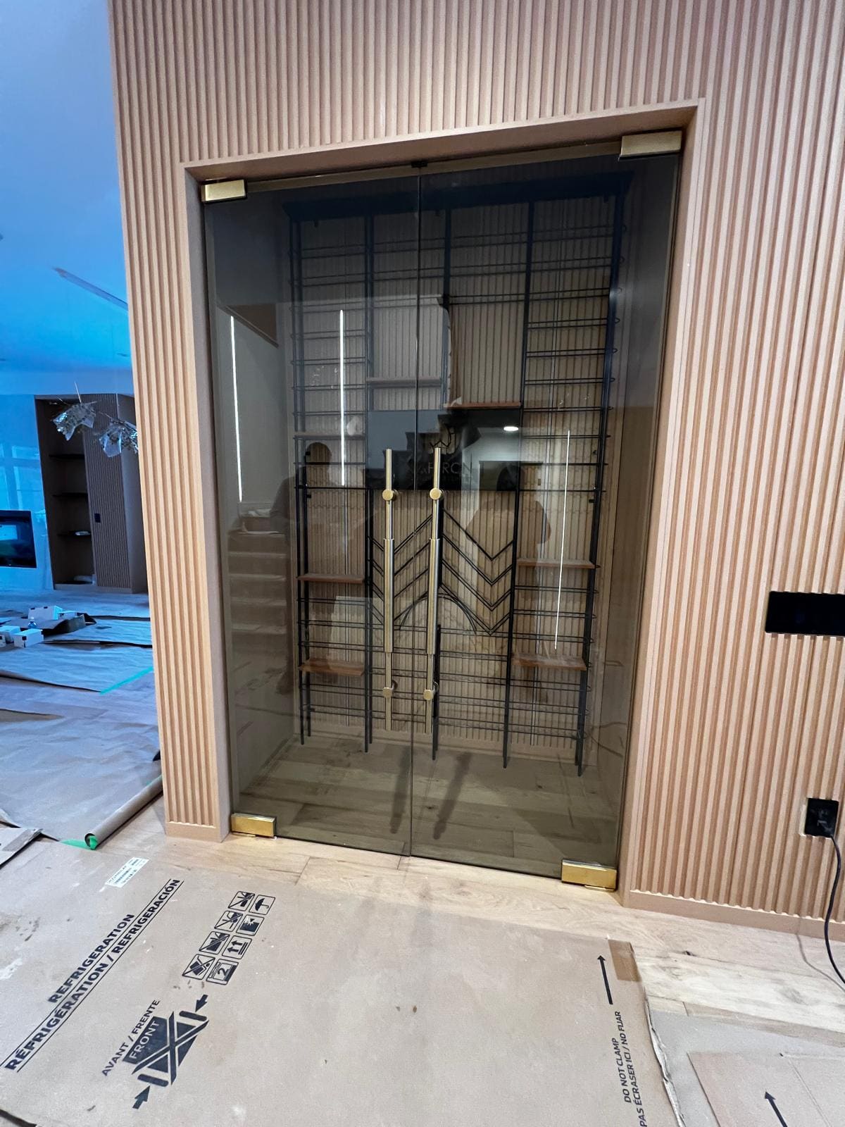Glass wine room doors with brass pulls in a fluted wall