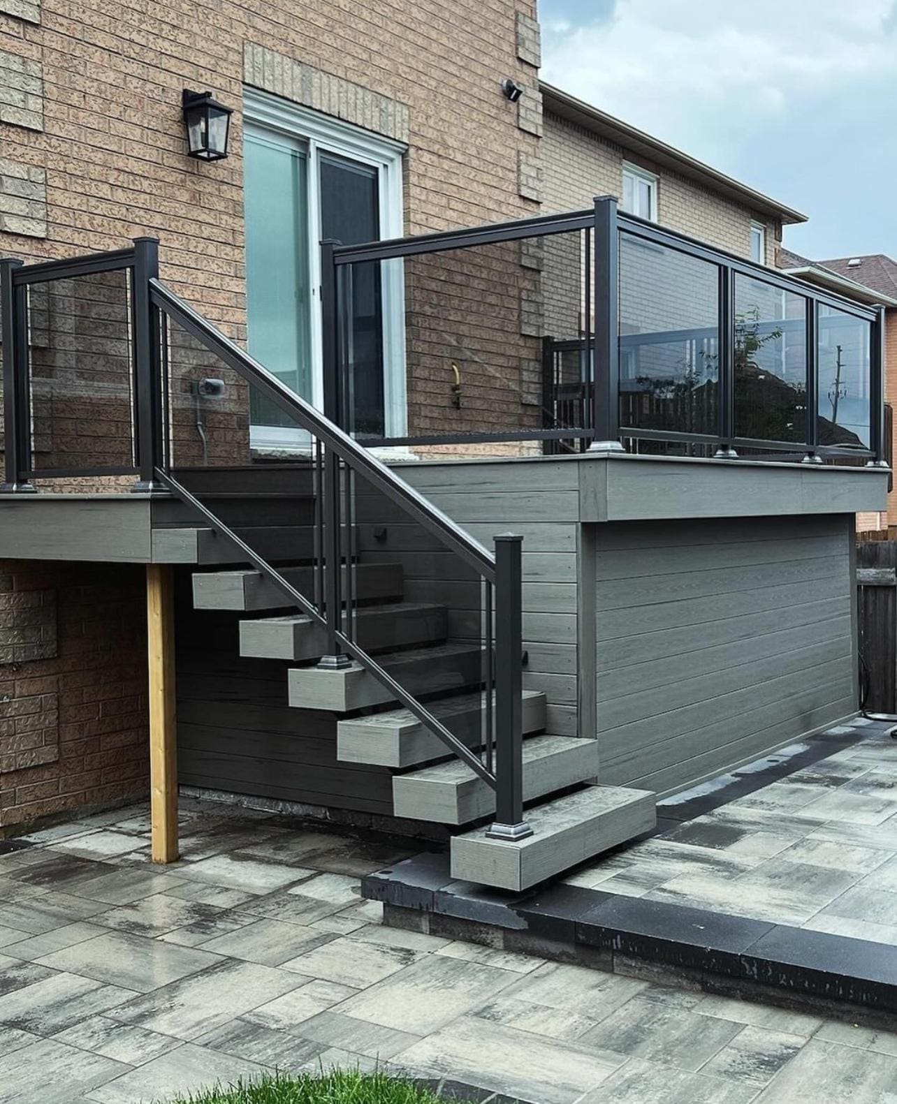 Black aluminum railing with glass infill around a deck