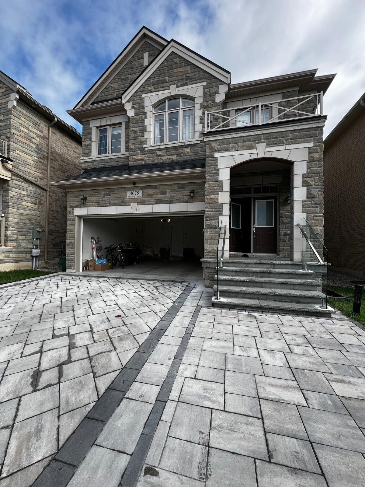 Frameless glass and a stainless handrail on a wide stone entry stair