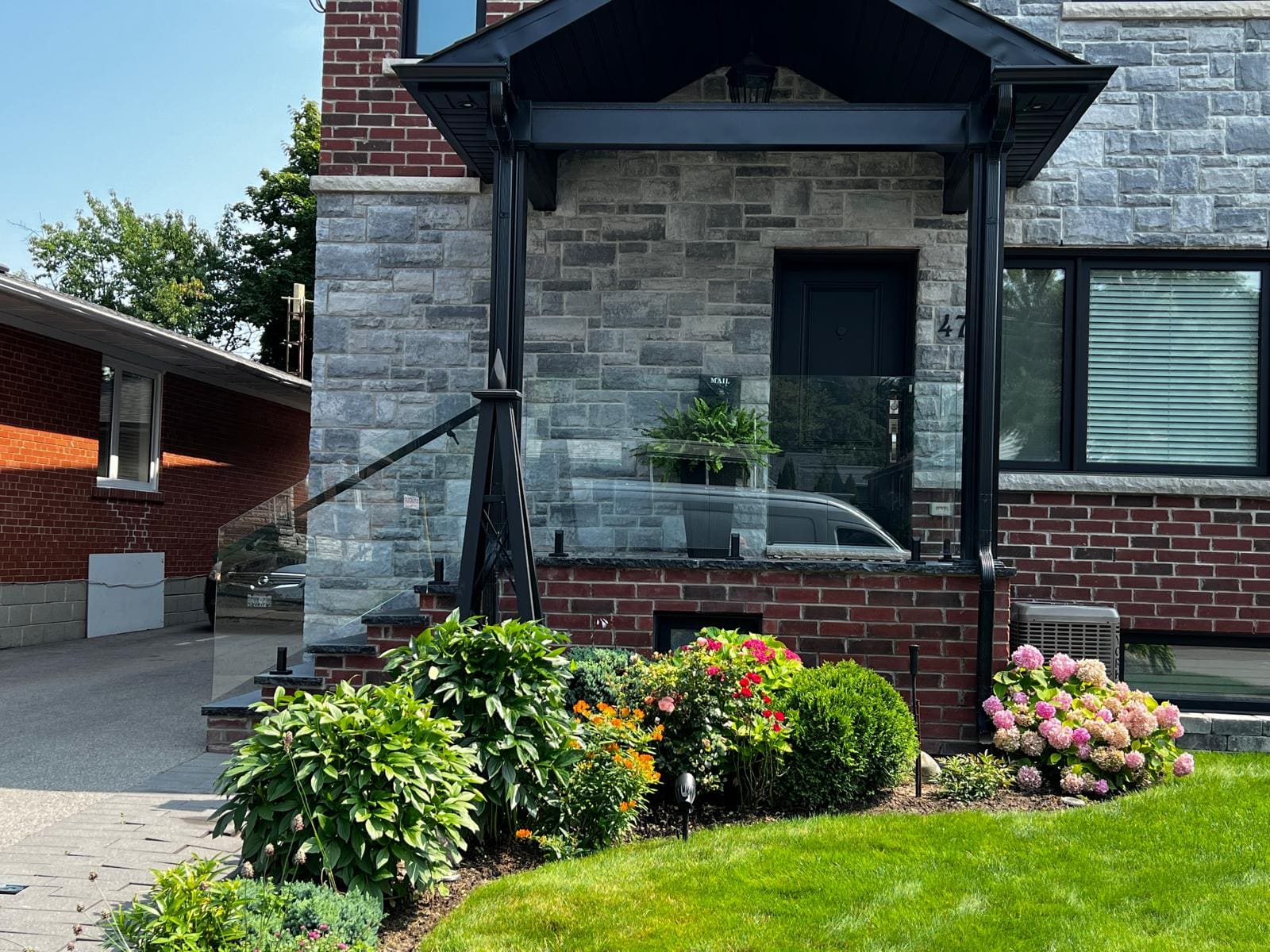 Spigot-mounted glass guard across a stone porch, installed by Reis Glass