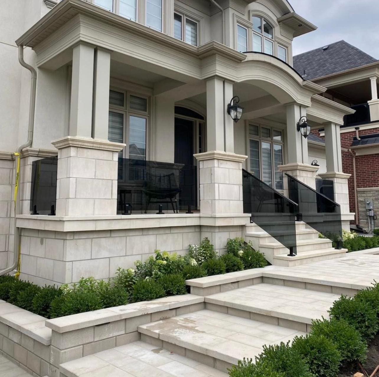 Grey-tinted glass with a black handrail on a cut-stone entry stair