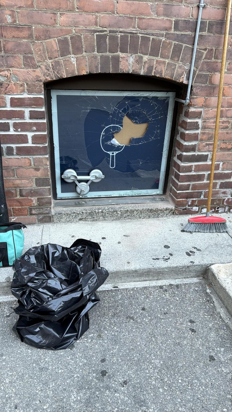 Broken basement window in a brick wall, replaced
