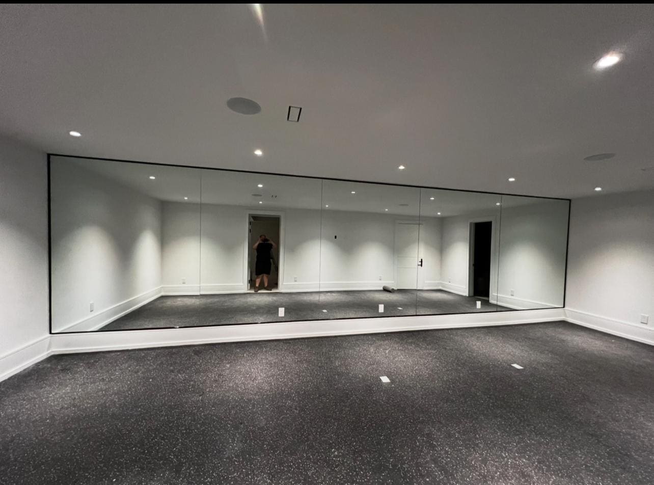 Full-width mirror wall in a basement home gym
