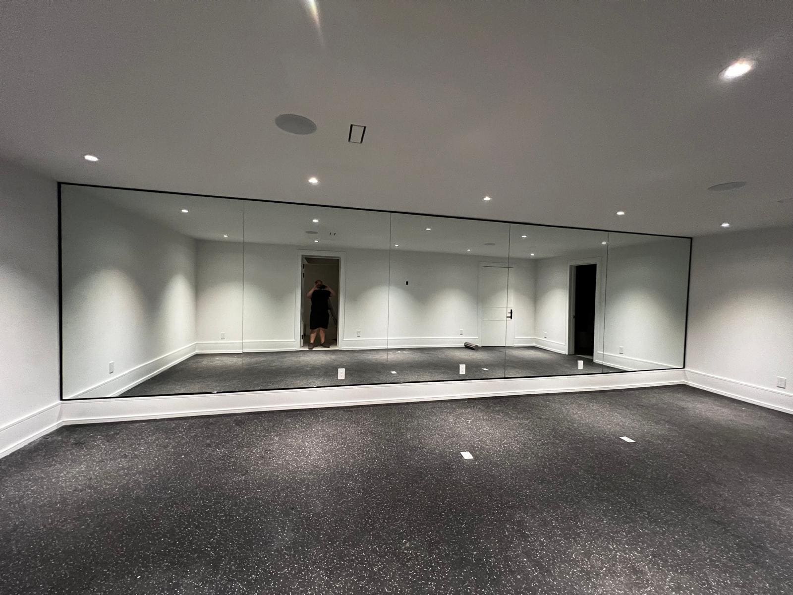 Full-width mirror wall in a basement home gym