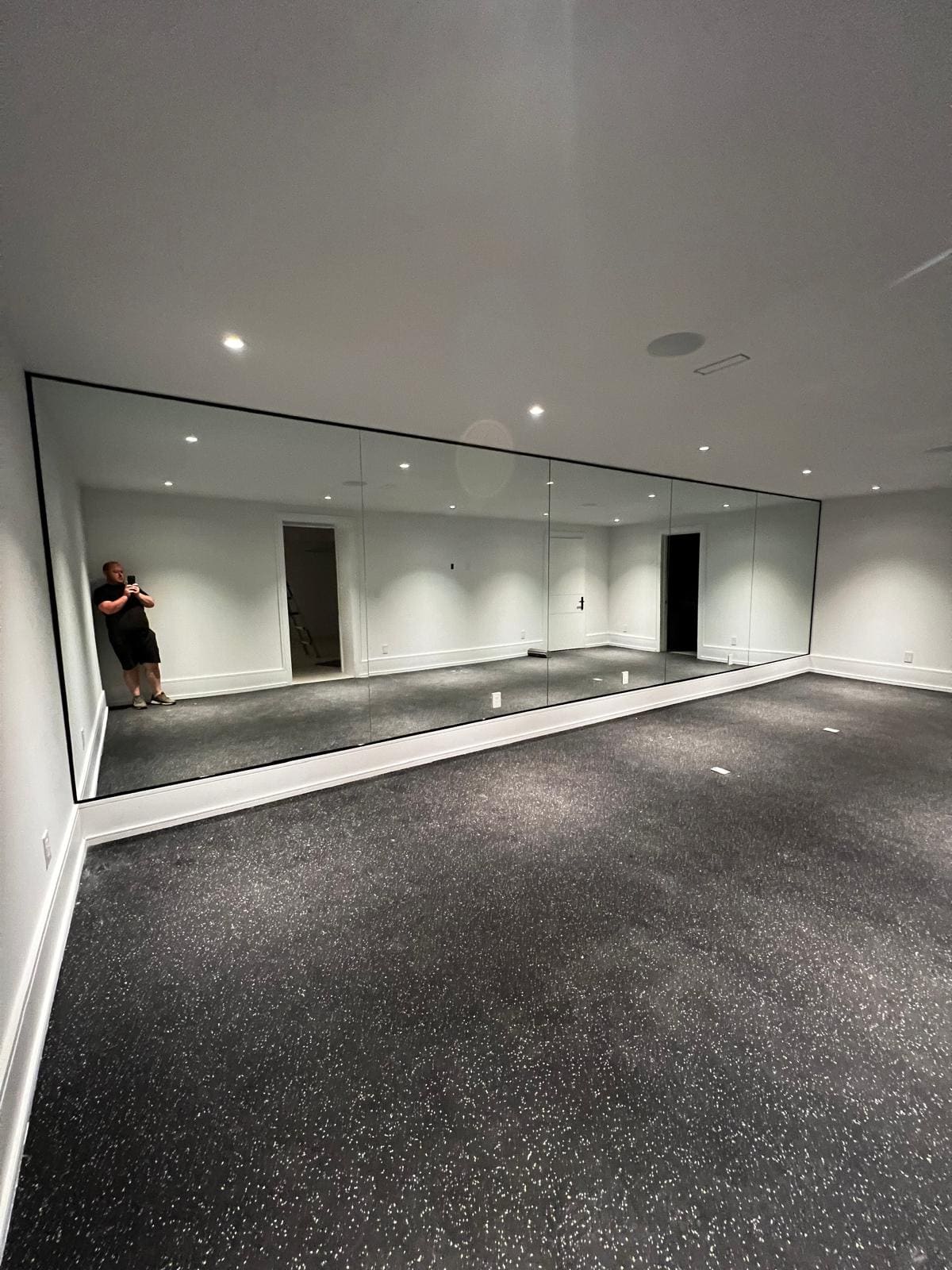 Full-width mirror wall in a basement home gym