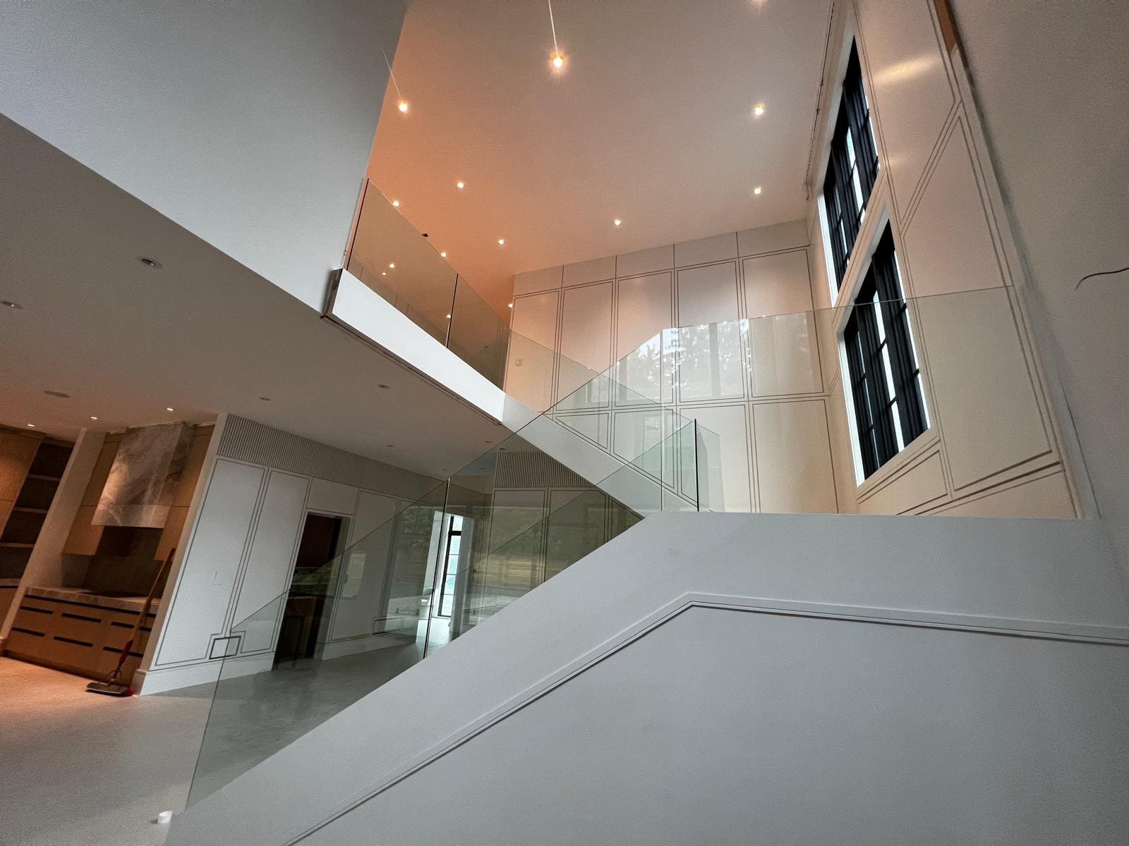 Frameless glass around a switchback stair in a double-height hall
