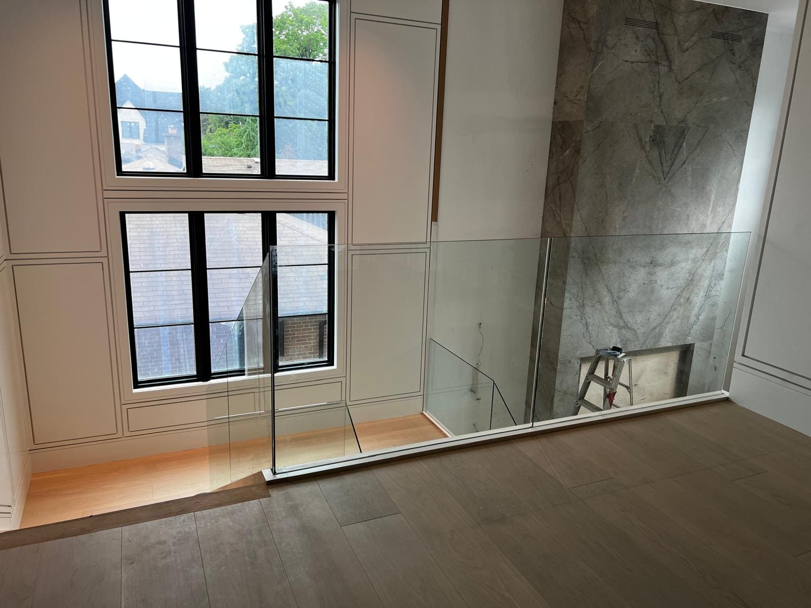 Frameless glass around a switchback stair in a double-height hall