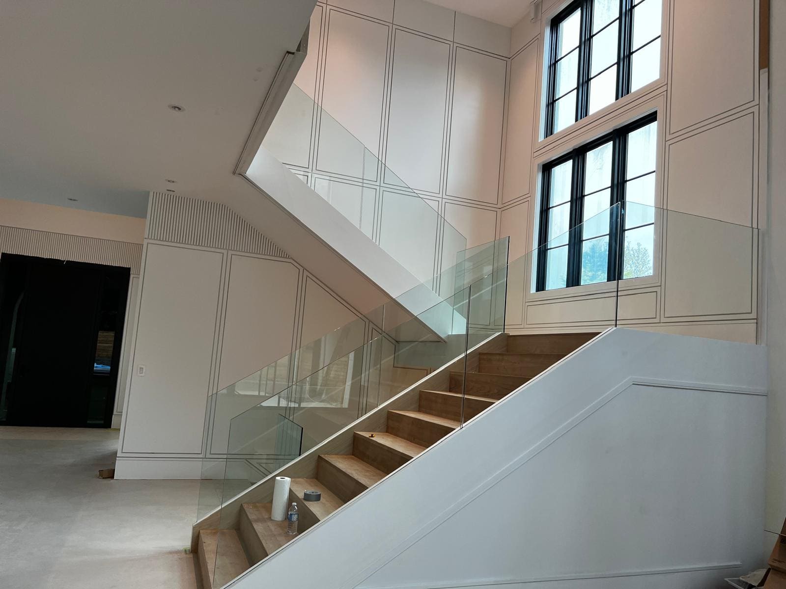 Frameless glass around a switchback stair in a double-height hall