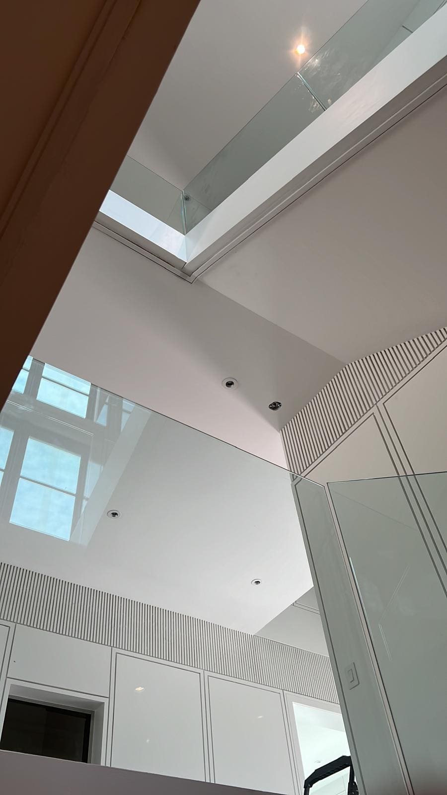 Frameless glass around a switchback stair in a double-height hall