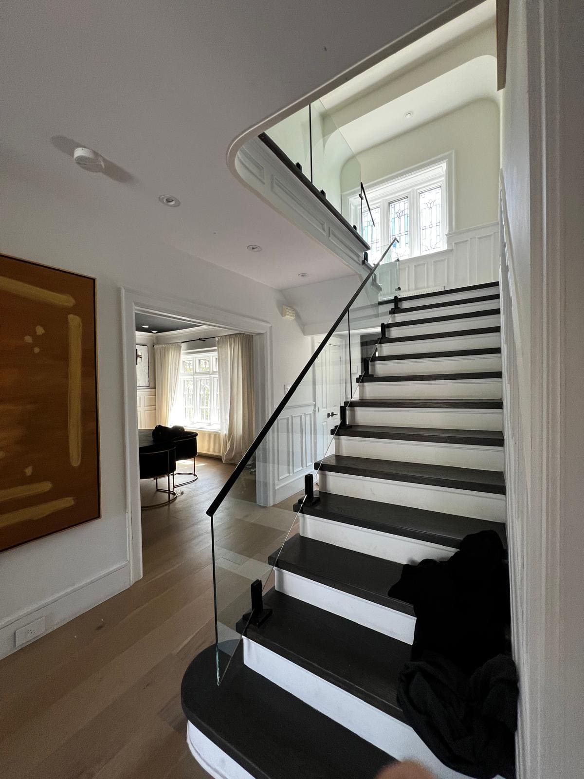 Frameless glass following an interior stair with dark treads, installed by Reis Glass