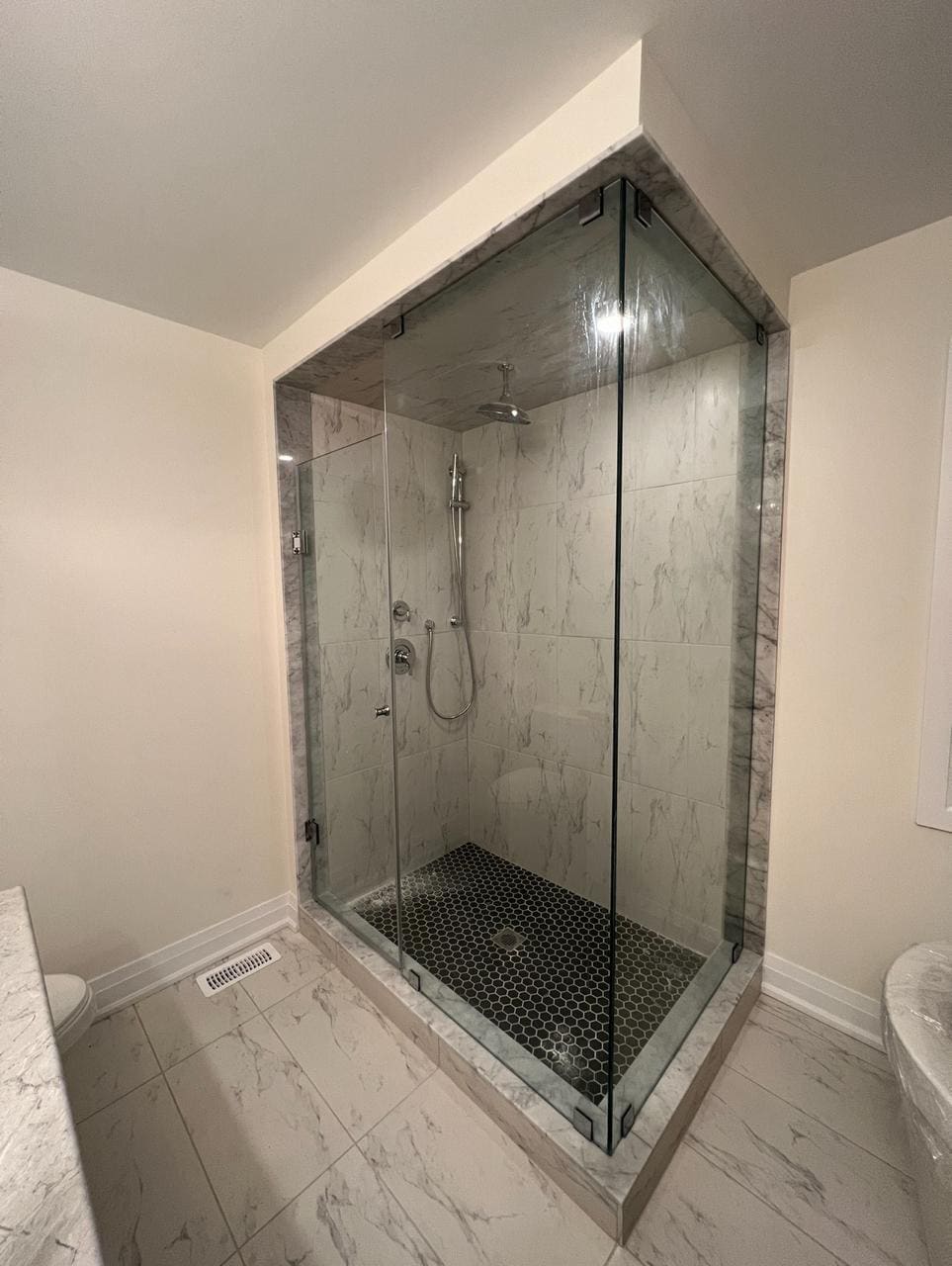 Glass corner shower next to a freestanding tub