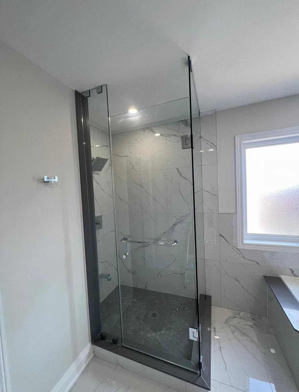 Frameless corner shower beside a window