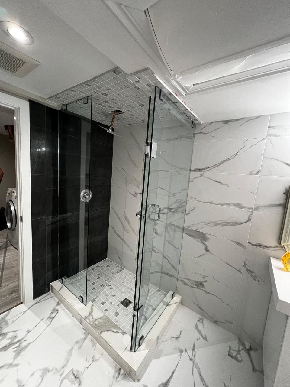 Glass corner shower against a black feature wall