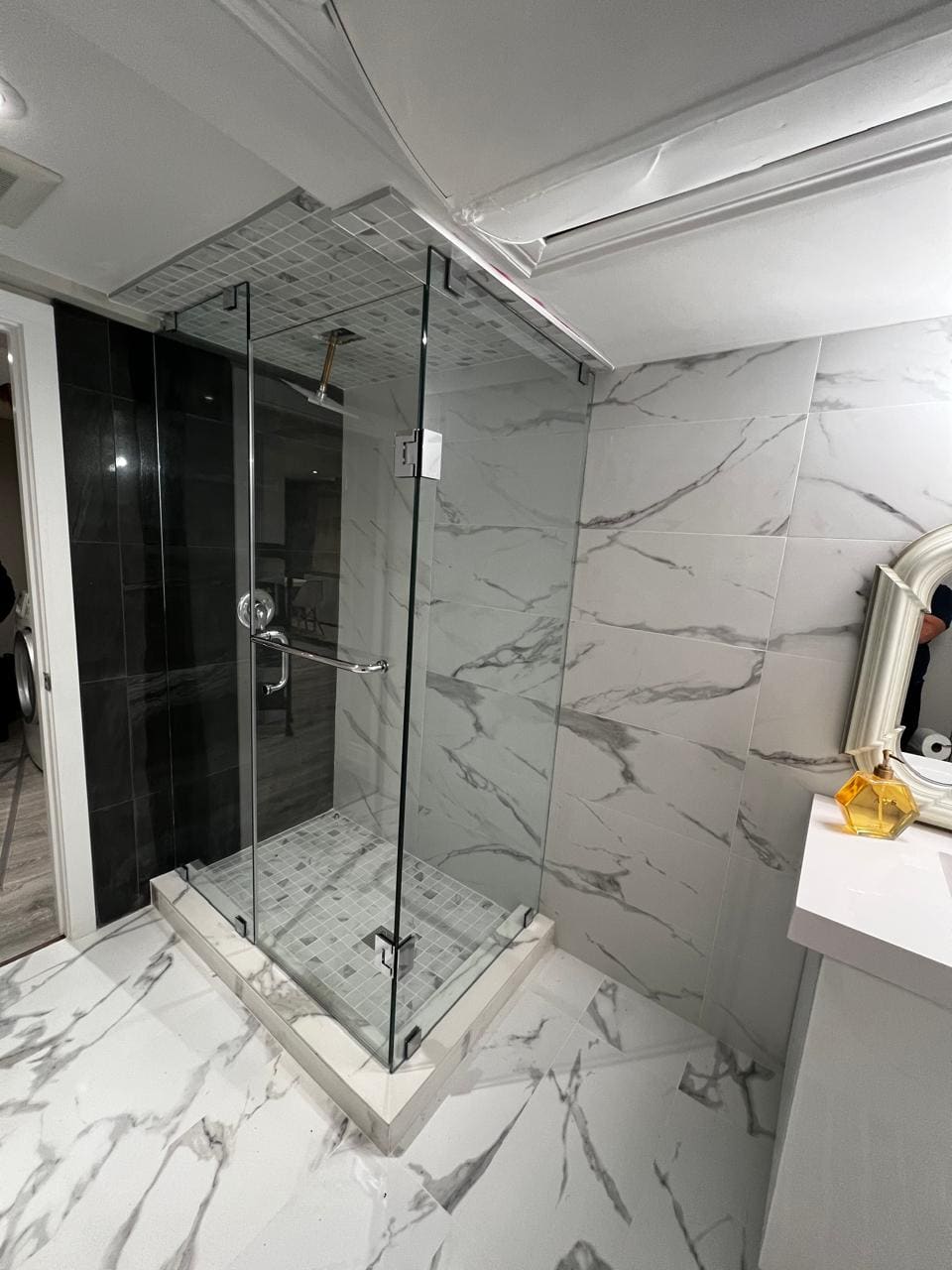 Glass corner shower against a black feature wall