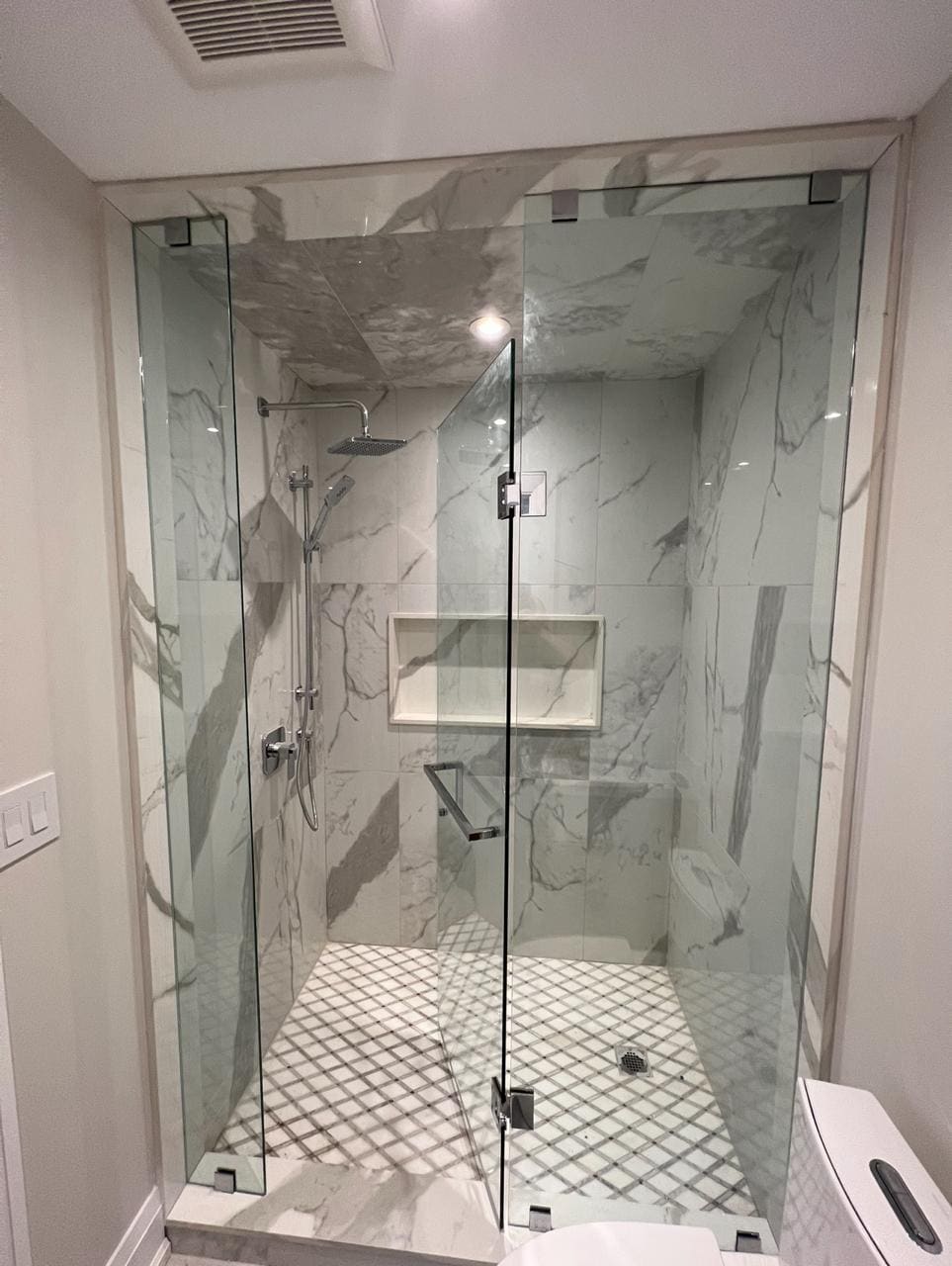 Frameless panel and door on a marble walk-in shower